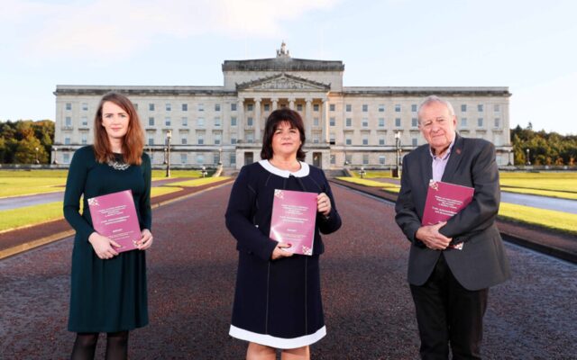 Truth Recovery Panel standing in front of Stormont holding reports.